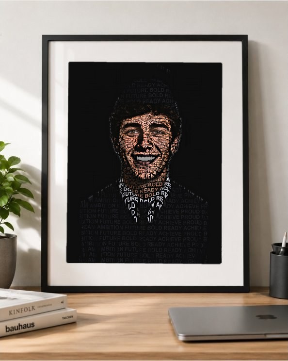 Framed word-art portrait of a graduate, matted in a black frame on a desk